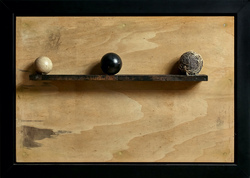 Three spheres: one white; one black; one grey with fibers.