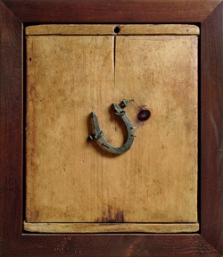 A horseshoe is nailed to a wooden cutting board.